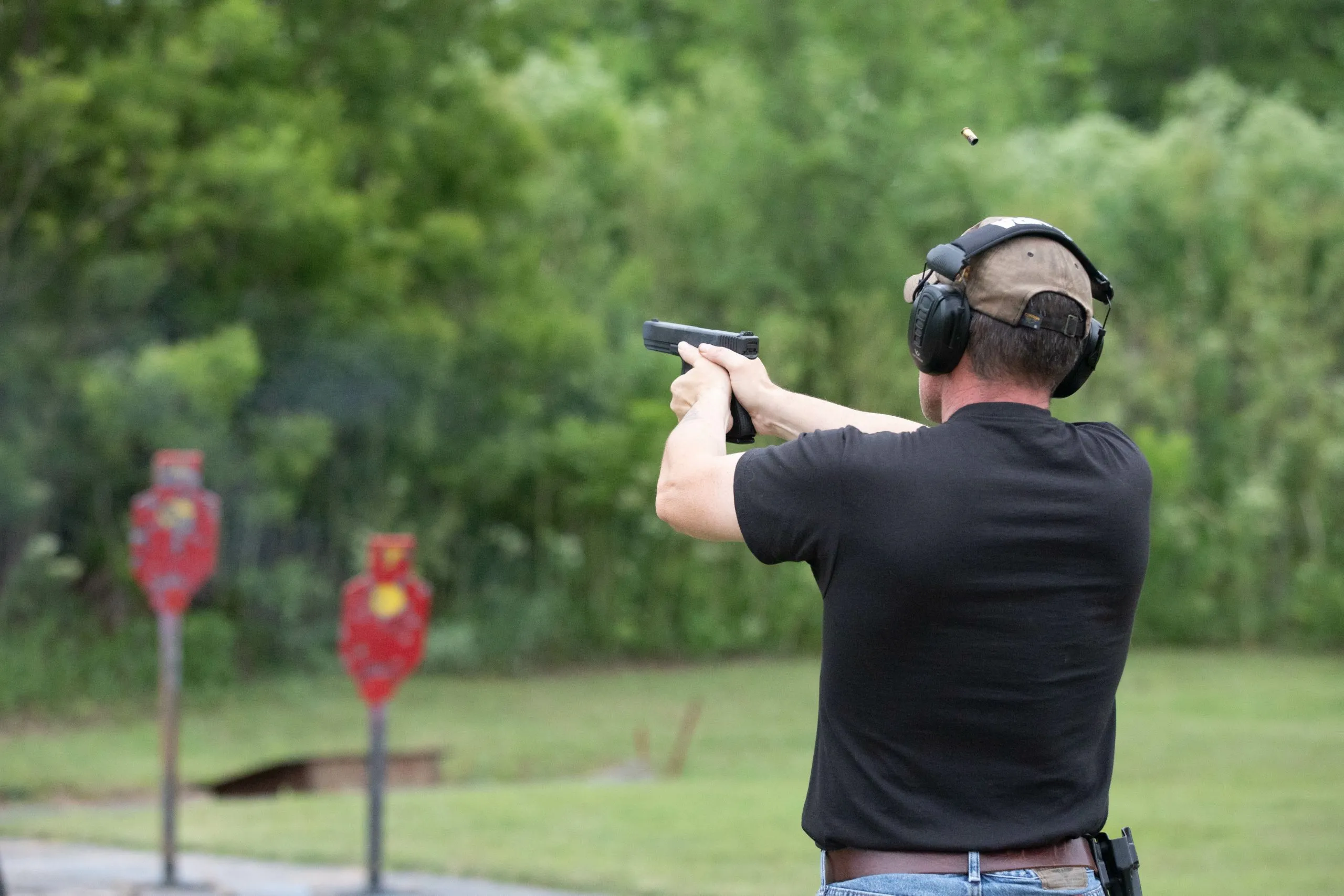 Man shooting with a gun at outdoor range